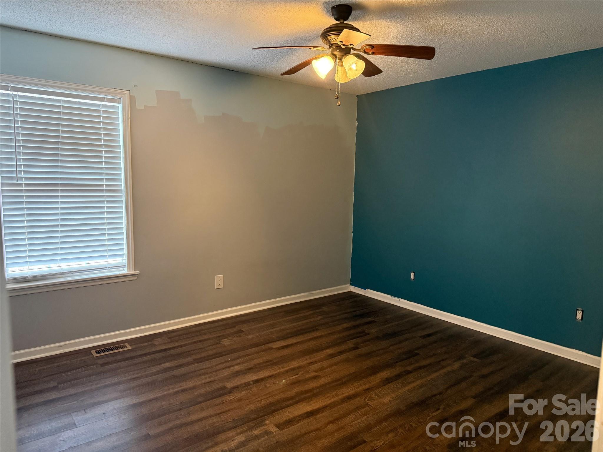309 Mel Lane Crouse, NC 28033 - Photo 20 of 35 an empty room with wooden floor chandelier fan and windows