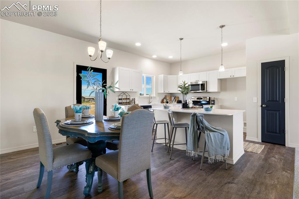 208 High Meadows Drive Florence, CO 81226 - Photo 12 of 32 a view of a dining room with furniture and wooden floor