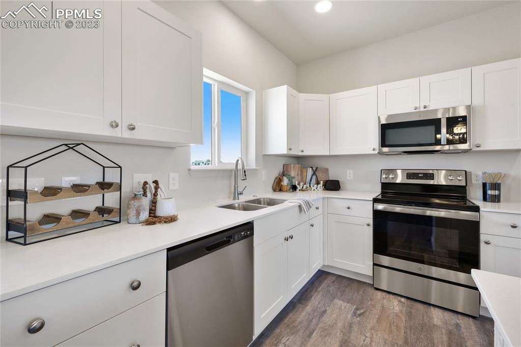 208 High Meadows Drive Florence, CO 81226 - Photo 13 of 32 a kitchen with stainless steel appliances granite countertop a sink a stove and a microwave