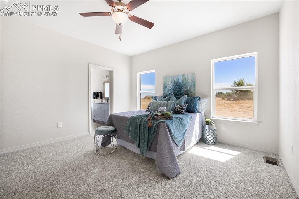 208 High Meadows Drive Florence, CO 81226 - Photo 17 of 32 a spacious bedroom with a bed and a chandelier