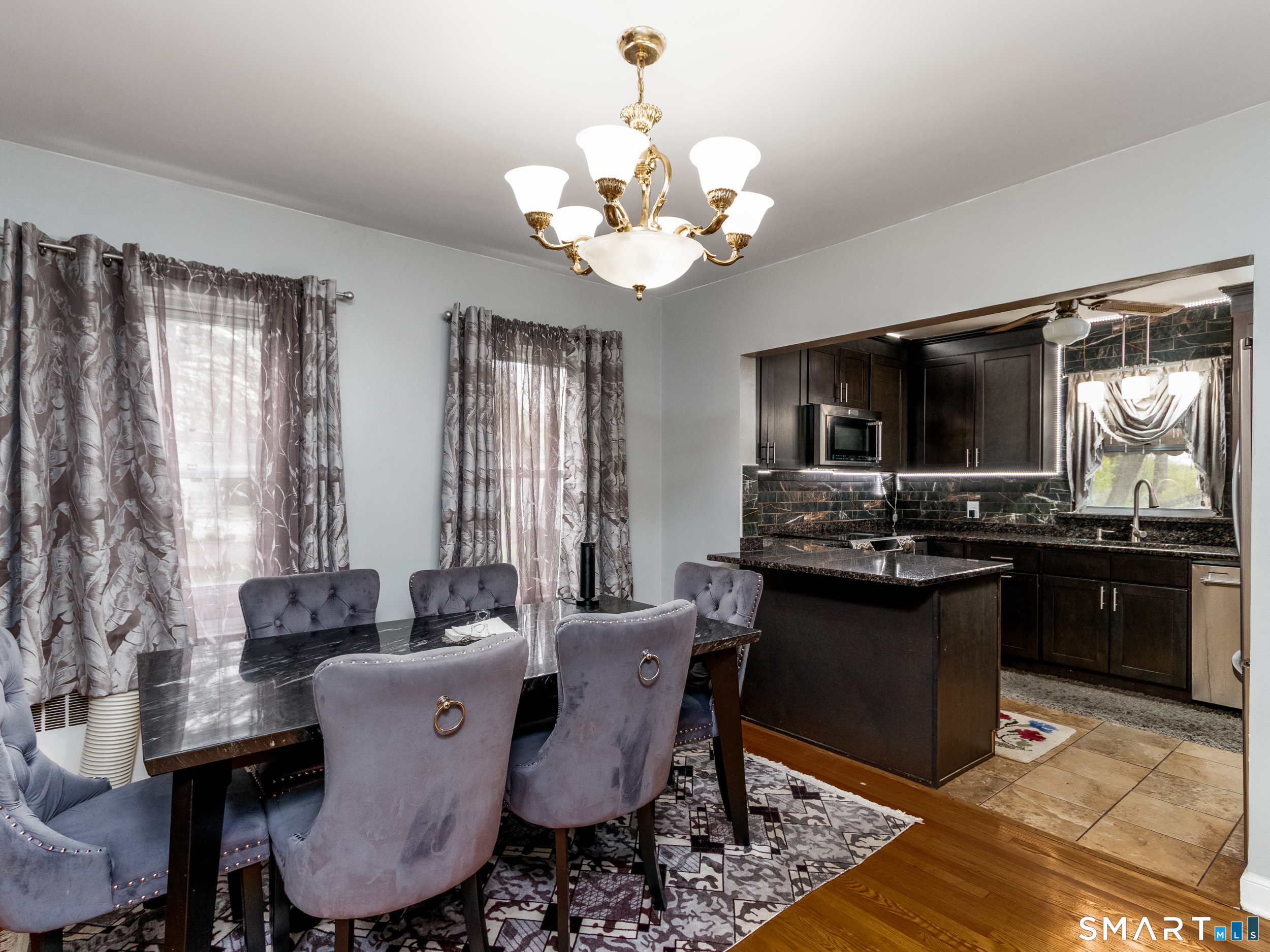 236 Hall Avenue Wallingford, CT 06492 - Photo 27 of 40 a dining room with wooden floor a chandelier a wooden table and chairs
