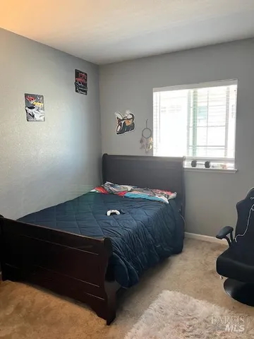 a bedroom with a bed and a lamp on dresser