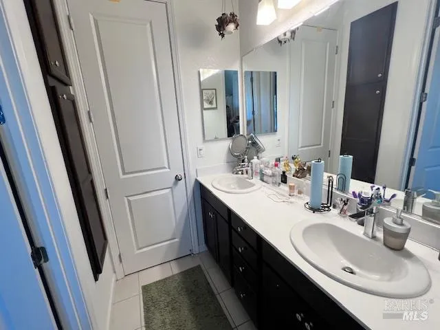 a bathroom with a double vanity sink a toilet and a mirror