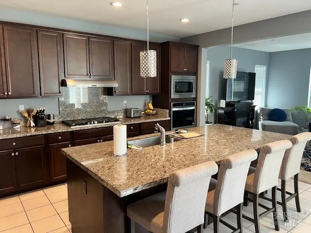 a kitchen with granite countertop a table chairs microwave and cabinets