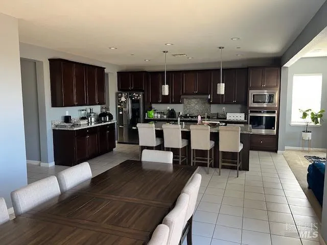 a kitchen with stainless steel appliances kitchen island granite countertop a refrigerator and a stove top oven