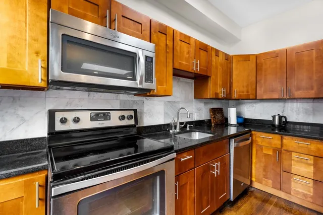 a kitchen with stainless steel appliances granite countertop a stove microwave and sink
