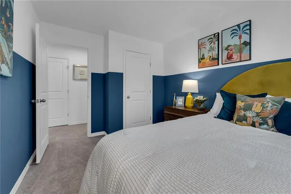 a bedroom with a bed and painting on the wall