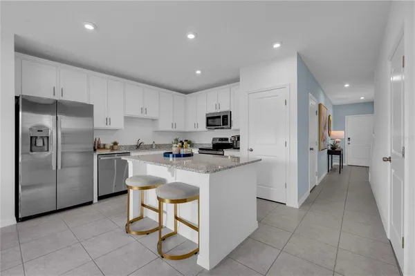 a kitchen with white cabinets and stainless steel appliances