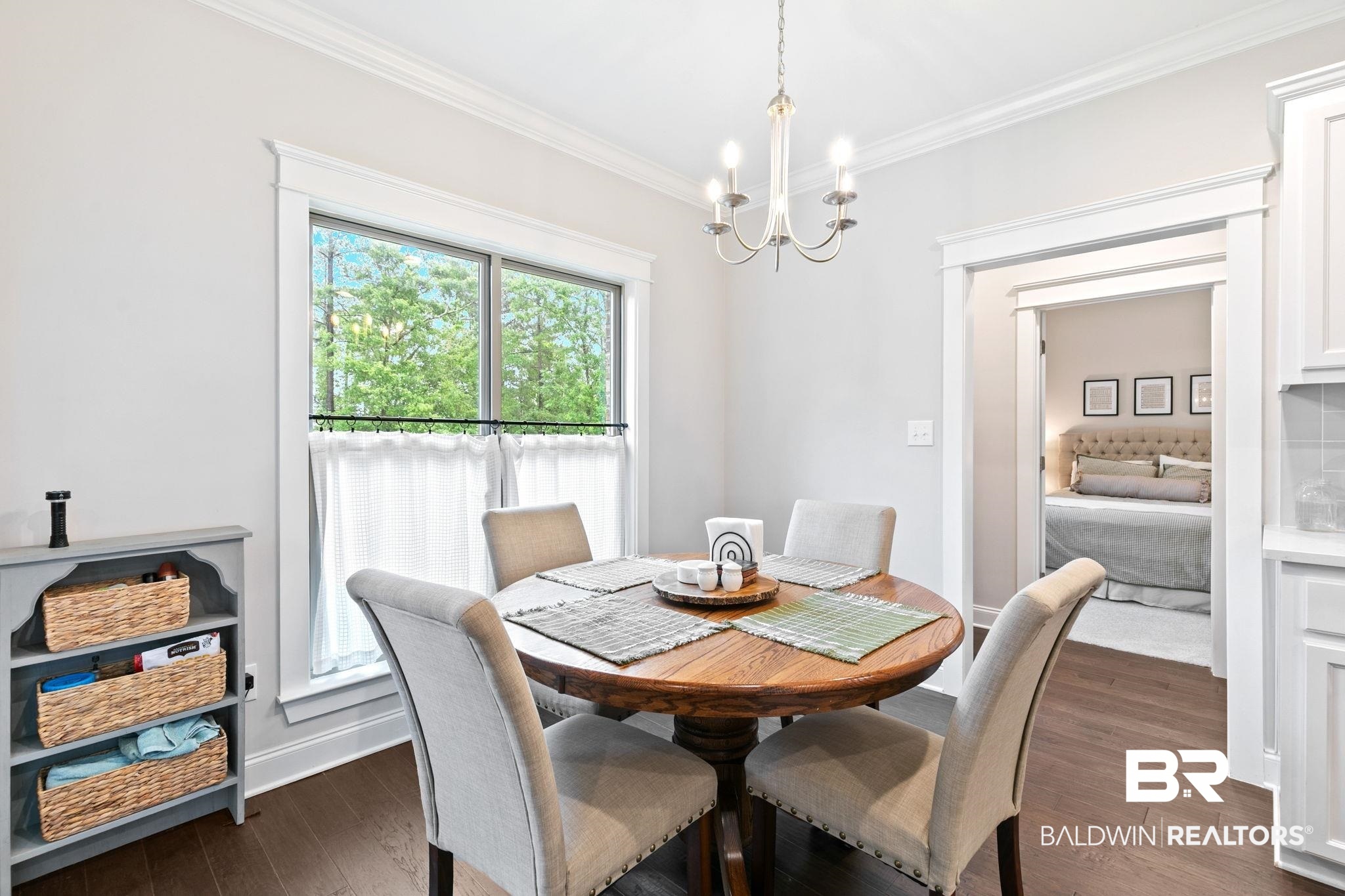 13233 Ibis Boulevard Daphne, AL 36527 - Photo 22 of 100 Dining area featuring a circular wood-finish table, four upholstered chairs with stud detailing, and a white chandelier