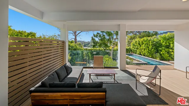 a view of a patio with a table chairs and a floor to ceiling window