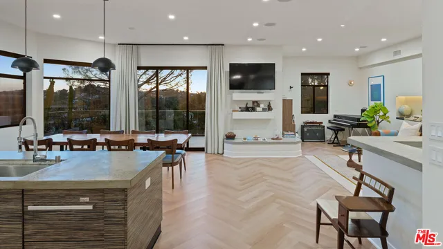 a room with stainless steel appliances lots of counter space dining table and chairs