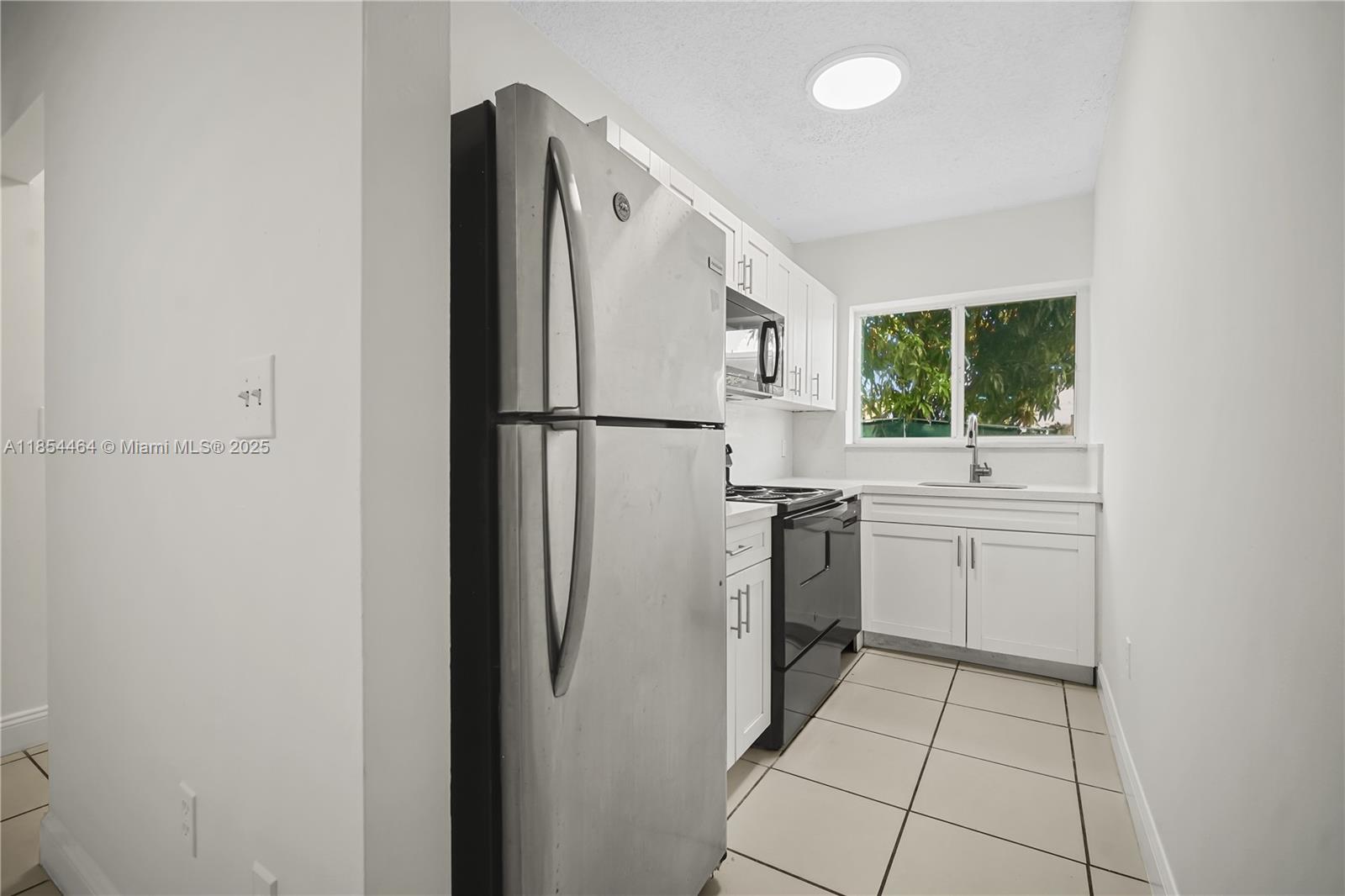 2622 Northwest 24th Street, Unit 2 Miami, FL 33142 - Photo 5 of 20 a white refrigerator freezer sitting inside of a kitchen