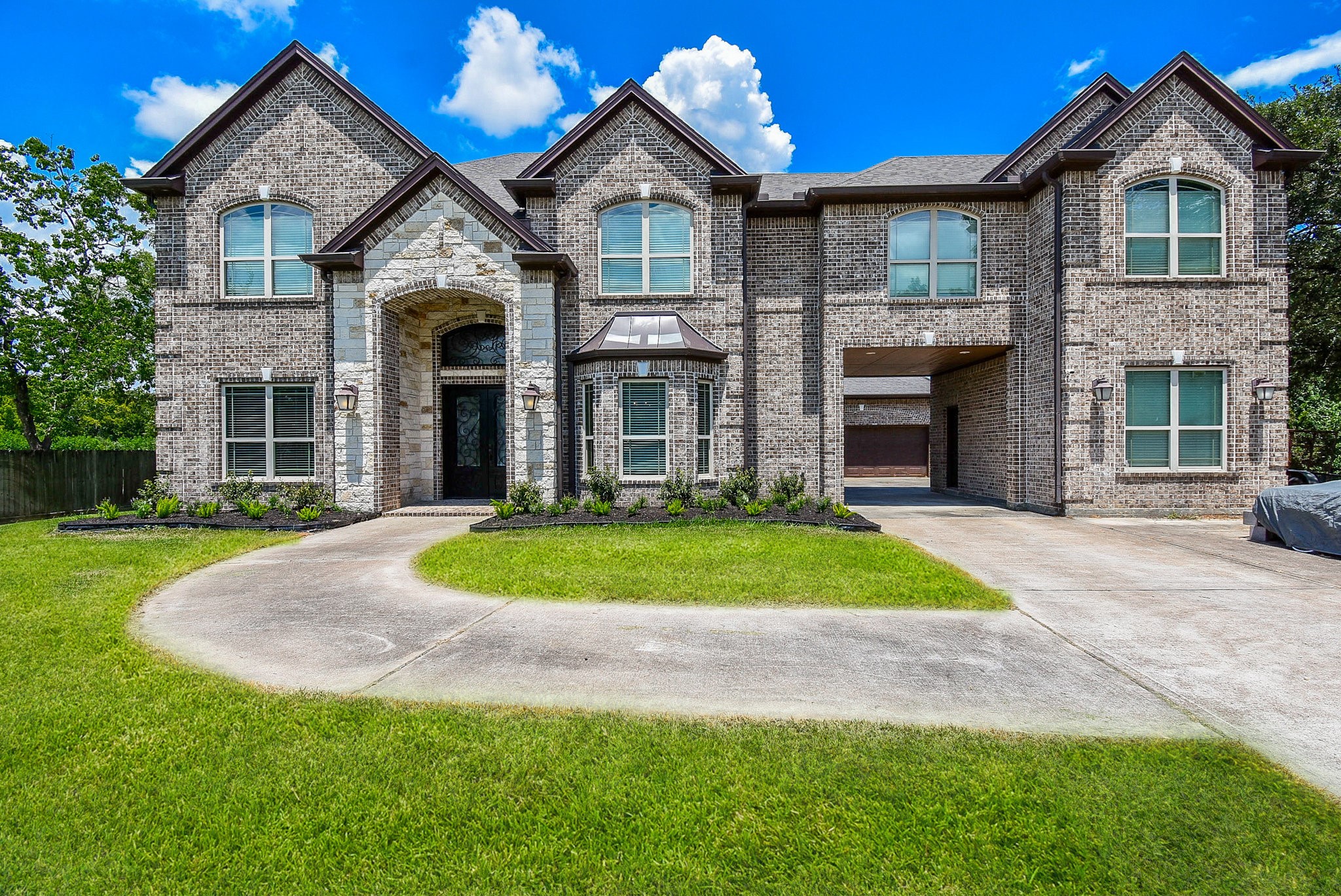 633 Crenshaw Road Houston, TX 77504 - Photo 3 of 46 This impressive home features a large, brick exterior with a grand entrance and arched windows. The spacious driveway includes a covered portico, and the well-maintained lawn offers great curb appeal. Perfect for buyers seeking elegance and space.