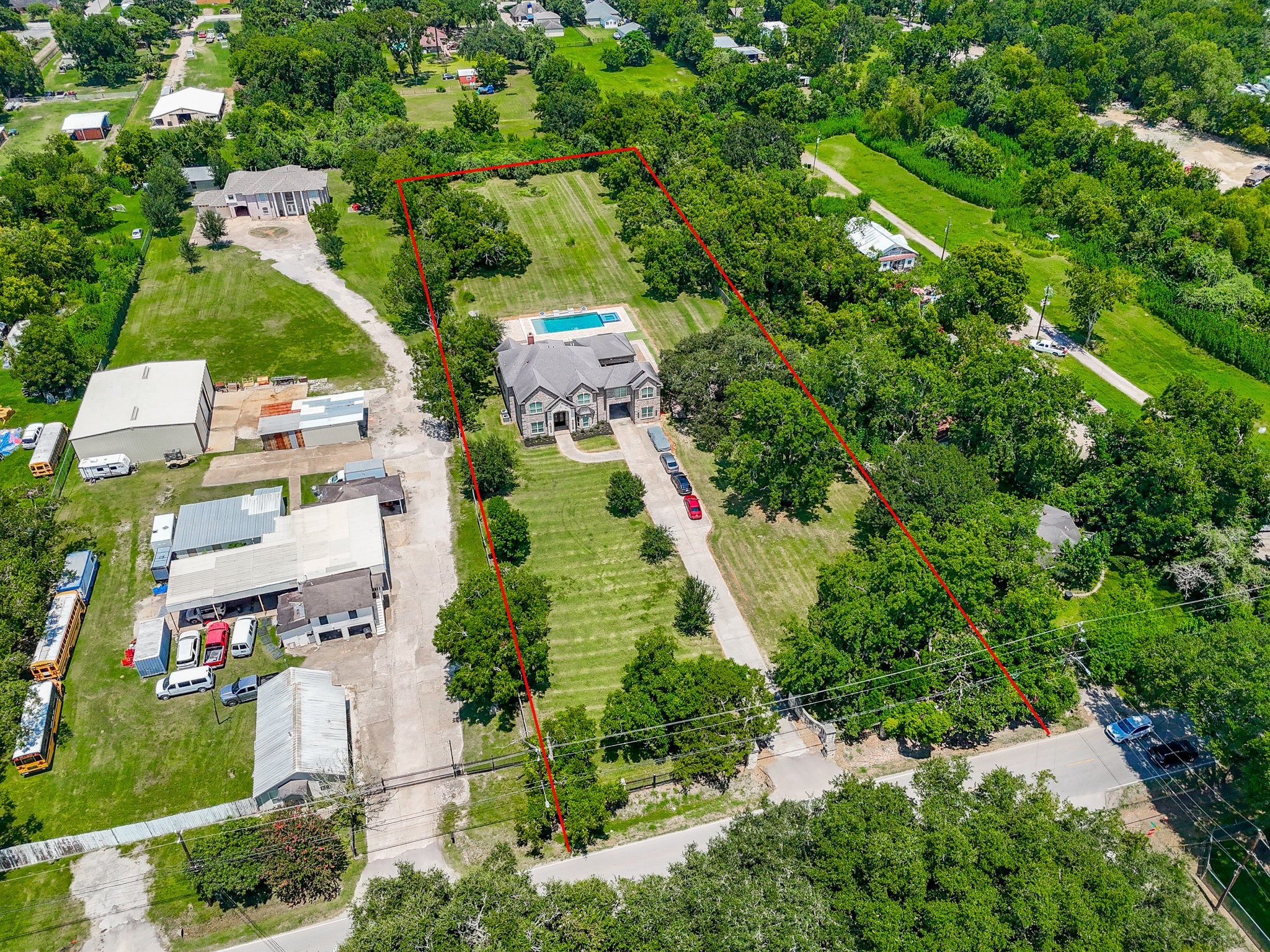 633 Crenshaw Road Houston, TX 77504 - Photo 38 of 46 This aerial view showcases a spacious property with a large home, pool, and extensive green lawn, bordered by trees for privacy. It's set in a semi-rural area with neighboring structures, providing a blend of tranquility and accessibility.