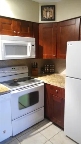 a bathroom with a granite countertop sink and a toilet