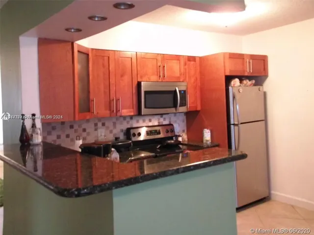 a bathroom with a granite countertop toilet and sink