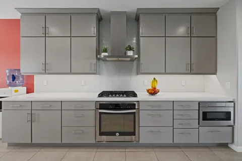 a kitchen with white cabinets and appliances