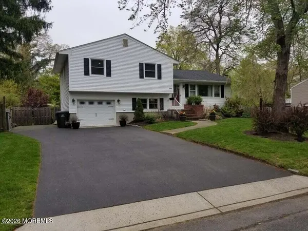 a front view of a house with a yard and trees