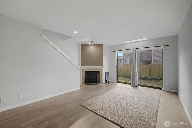 an empty room with fireplace and windows