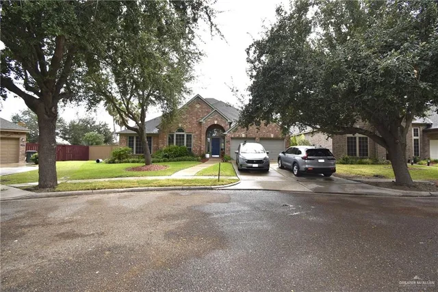 a view of a house with a big yard and large trees