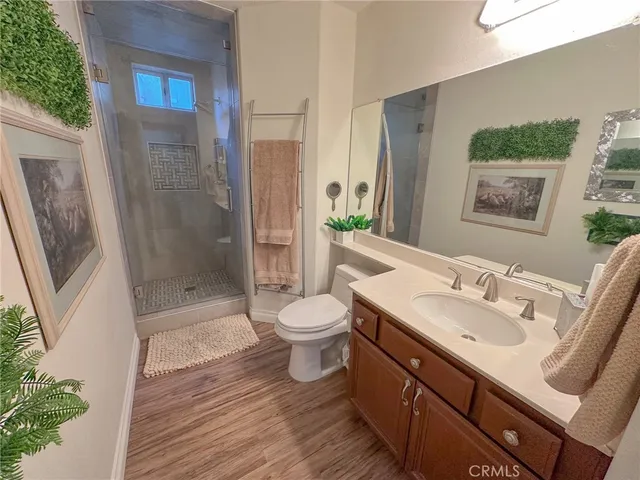 a bathroom with a sink a toilet a mirror and shower