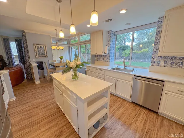 a kitchen with wooden floors and white cabinets