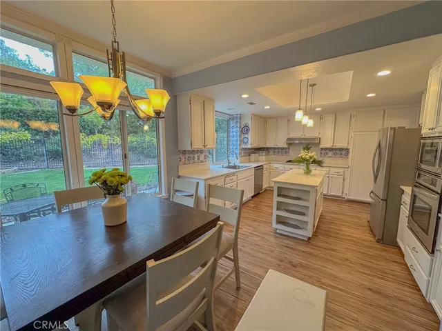 a kitchen with stainless steel appliances granite countertop a sink a stove and a refrigerator