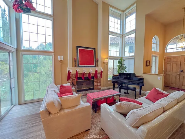 a living room with furniture a fireplace and a floor to ceiling window