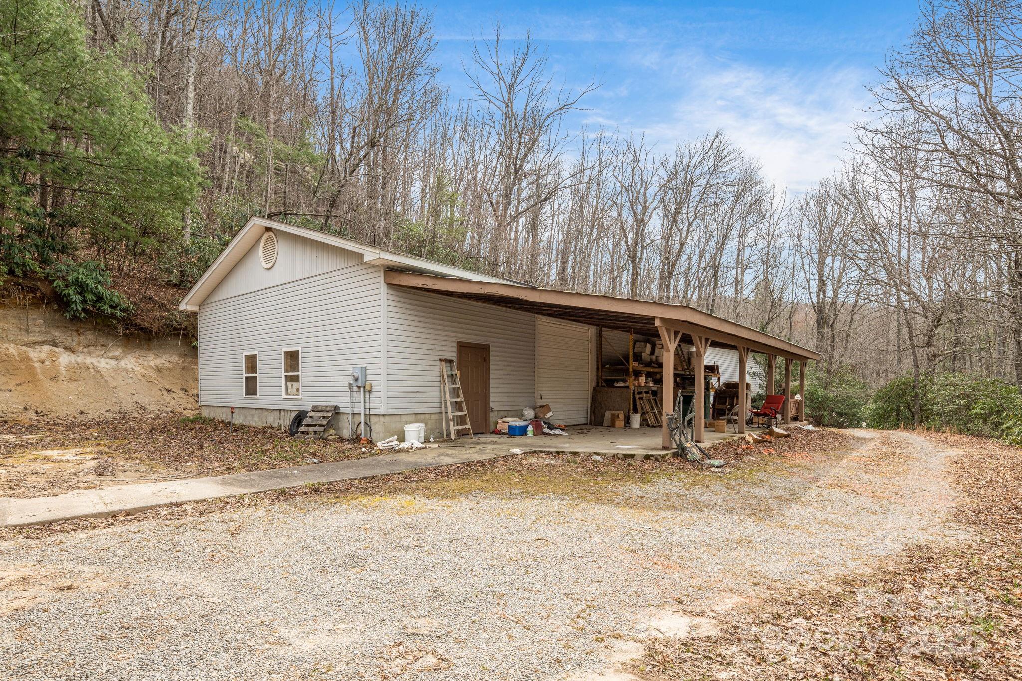 5389 Cascade Lake Road Cedar Mountain, NC 28718 - Photo 11 of 39 a backyard of a house with table and chairs under an umbrella