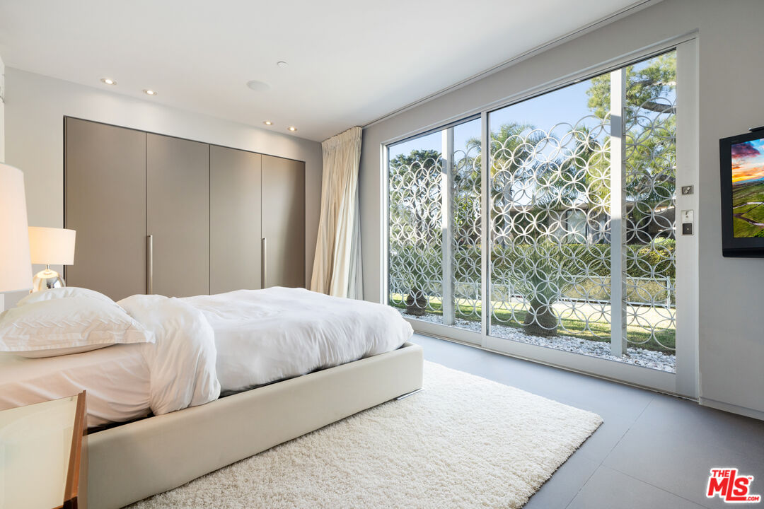 1610 Carla Ridge Beverly Hills, CA 90210 - Photo 12 of 14 a bedroom with a large bed and a large window