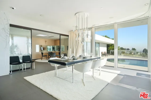 a living room with couches a table and chairs with wooden floor