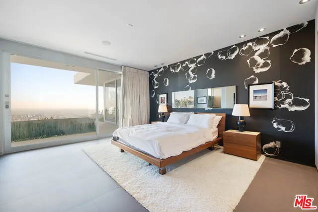 a bedroom with a large bed and a large window