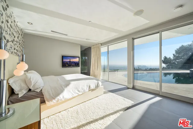 a bedroom with a bed and a large window