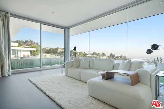 a living room with furniture and a floor to ceiling window