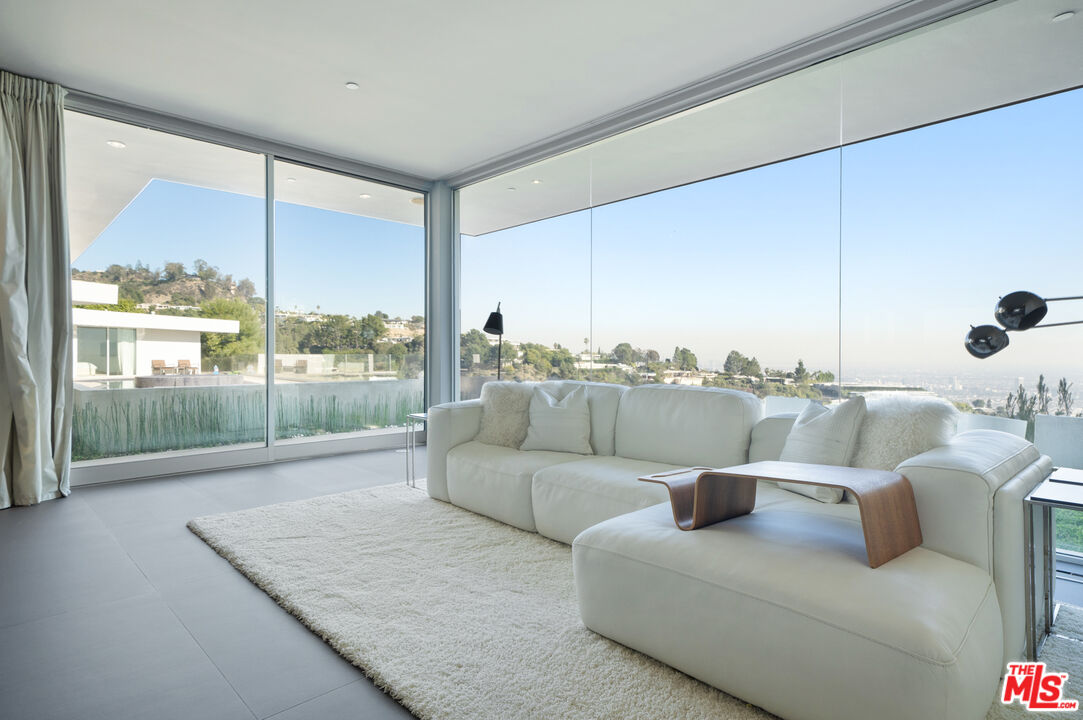 1610 Carla Ridge Beverly Hills, CA 90210 - Photo 9 of 14 a living room with furniture and a floor to ceiling window