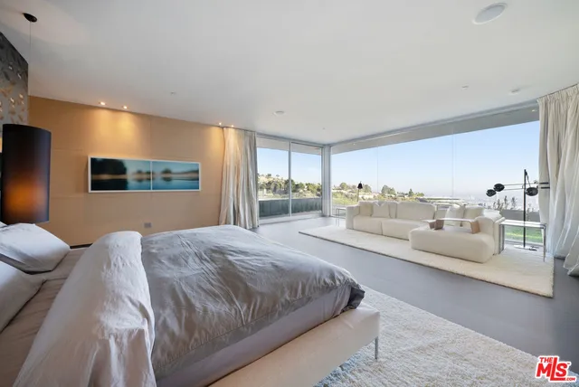 a spacious bedroom with a large bed and a large window