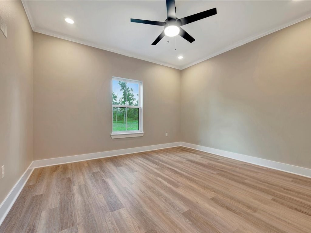 537 C C Road Diboll, TX 75941 - Photo 29 of 37 an empty room with wooden floor ceiling fan and windows