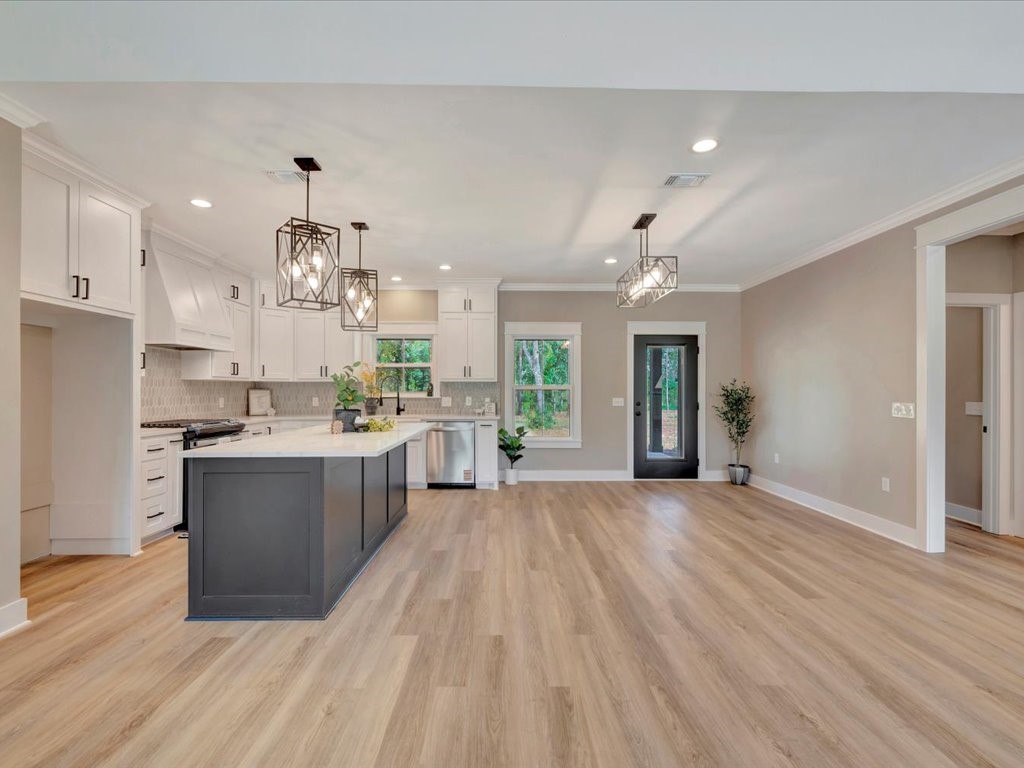 537 C C Road Diboll, TX 75941 - Photo 10 of 37 a large kitchen with kitchen island a sink dishwasher stove and white cabinets next to a window