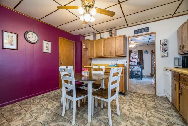 a dining room with stainless steel appliances kitchen island granite countertop a refrigerator and a stove top oven