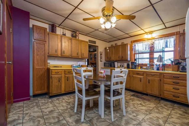 a kitchen with stainless steel appliances kitchen island granite countertop a table chairs sink and cabinets