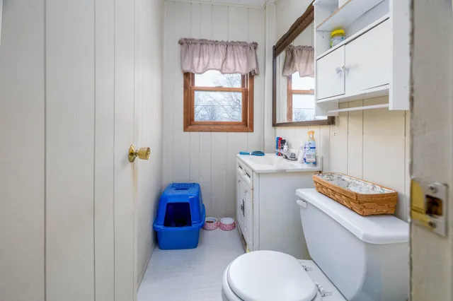 a bathroom with a sink toilet and window