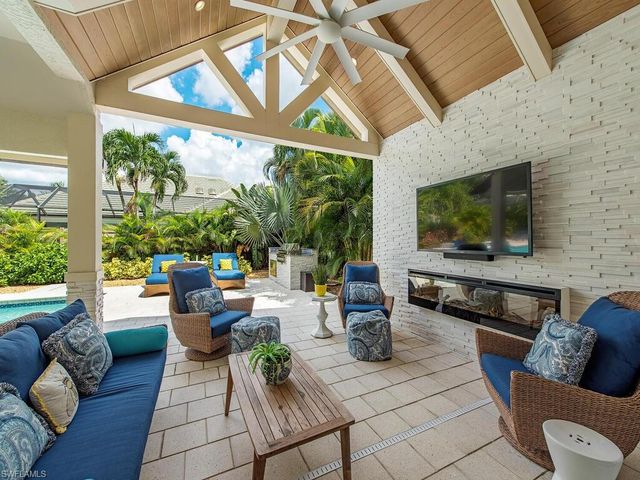 a living room with patio furniture and a flat screen tv