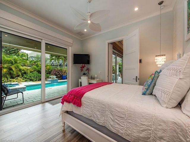 a bedroom with a bed and large windows