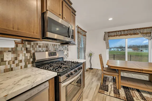 a kitchen with granite countertop a stove a sink and a microwave