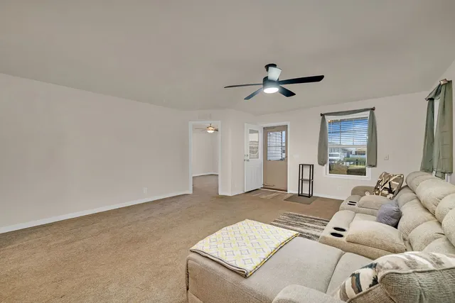 a living room with furniture and a ceiling fan