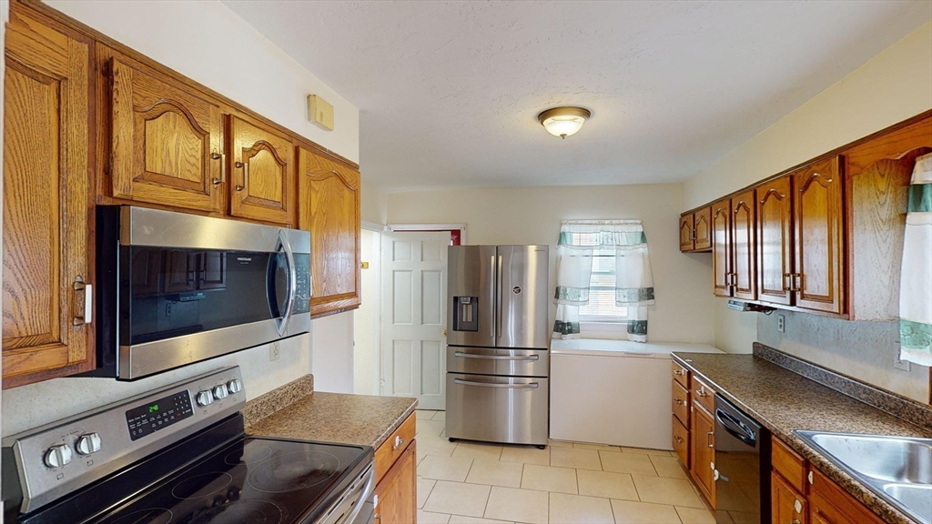 28 Brighton Road Worcester, MA 01606 - Photo 9 of 28 a kitchen with stainless steel appliances granite countertop a refrigerator a stove and a sink