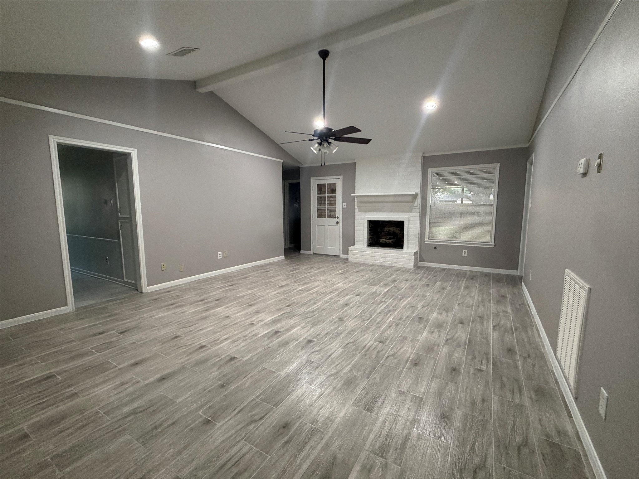 3815 Avenue R Rosenberg, TX 77471 - Photo 4 of 14 an empty room with wooden floor fireplace and windows