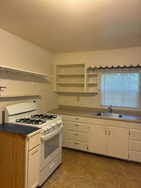 2823 Blair Road Pollock Pines, CA 95726 - Photo 6 of 15 a kitchen with granite countertop a stove a sink and white cabinets