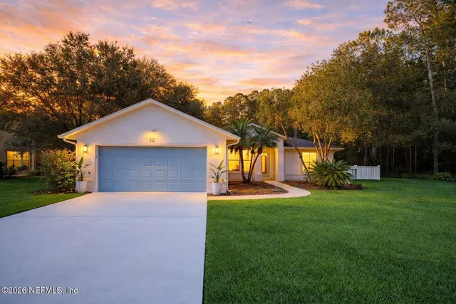 a front view of a house with a yard and trees