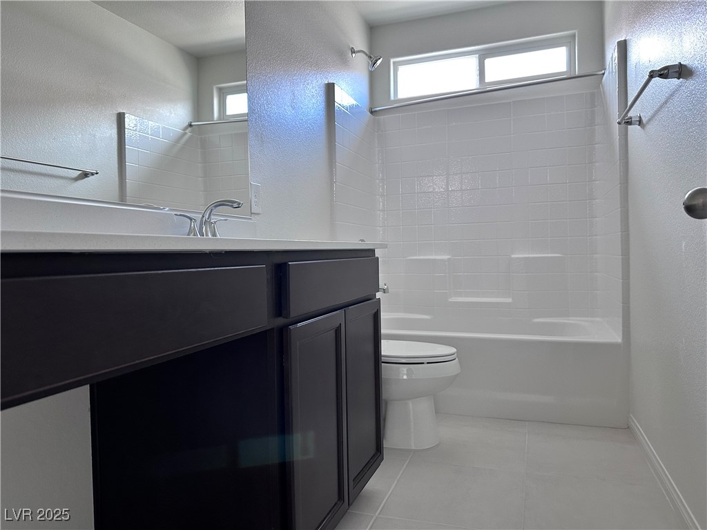 3634 Cameri Avenue Henderson, NV 89044 - Photo 12 of 22 Bathroom with a textured wall, shower / bathtub combination, vanity, and light tile patterned flooring